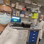 Rebekah and her colleague taking a selfie stood next to the GridION that sequences RNA and DNA in a laboratory setting.