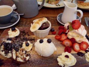 Platter of desserts from the Pudding Pantry in Nottingham. Brownie, sticky toffee pudding, and strawberries with meringue. 