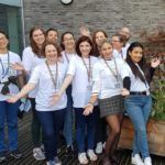 A group of people in white T-shirts saying "Doors Open Day" posing for the camera