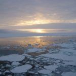Sunset over the ocean with sea-ice floating on the surface