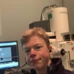 Picture of Ollie in front of a scanning electron microscope