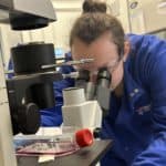 Grace looking at cells down a microscope