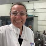 Grace smiling in a selfie, wearing a white lab coat.